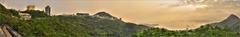 A vibrant panorama of The Peak in Hong Kong with lush greenery and cityscape under a clear sky