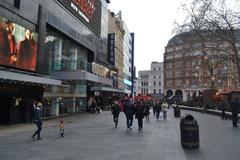 Leicester Square in London at dusk with illuminated buildings and busy streets