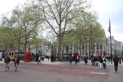 Leicester Square in London with busy crowds and greenery