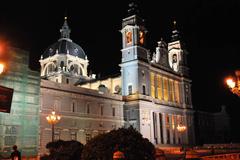 Panoramic view of Gran Vía in Madrid at dusk with illuminated buildings and bustling traffic