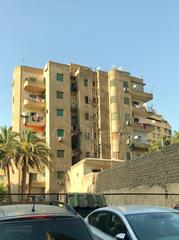 Abd El Aziz El Dorainy Street in Cairo showcasing buildings with Art Deco and early Modernism elements, featuring balconies, concrete detailing, and simple ornamentation