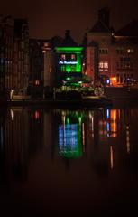 Amsterdam Centraal at night with city lights and reflection on water