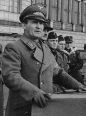 Karl Hanke in 1945 giving a speech at a podium with a swastika flag and helmet