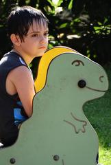 Boy sitting on a park bench surrounded by greenery in Palma de Mallorca, Spain