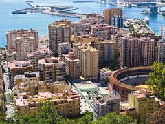 view from Gibralfaro fortress towards the south with bullfighting arena in foreground, high-rise buildings of Malaqueta, and harbor in the background