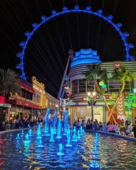 Linq Promenade at night with illuminated High Roller and fountains