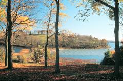 autumn tombolo at World's End connecting two drumlins with golden leaves, bench and trees in the foreground