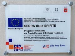 European Regional Development Fund sign at the greenhouse, Via Roma, Pisa Botanical Garden