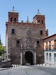 Brown and white adobe building with wooden balcony in a Spanish historical area