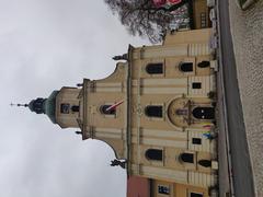 Exterior view of Our Lady Basilica in Rudy with lush green surroundings