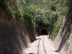 rock tunnel entrance with wooden post and signboard