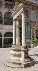 Pediment and colonnade over an old well in Piazza Mercanti, Milan