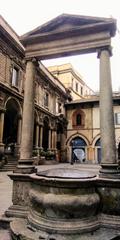 Merchant's Square in medieval Milan with historic pit, columns, Notary's Palace in the background, and Palazzo delle Scuole Palatine on the left