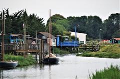 Scenic view of Mornac-sur-Seudre village with traditional buildings and boats along the river