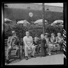 people sitting on benches in front of the Central Park Zoo restaurant