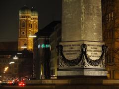 Frauenkirche and obelisk at Karolinenplatz at night in Munich