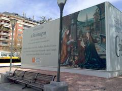 Cartel de la exposición 'A su imagen' con el Tríptico de la Anunciación de Joos van Cleve en la Plaza de Colón