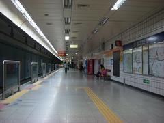 Yaksu Station underground subway platform with signage and passengers