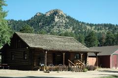 Log cabin at Elk Meadow Lodge and RV Resort in Estes Park surrounded by trees and greenery