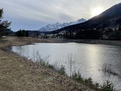 Lake Andalo under Piz Galin mountain with clear water and green forest