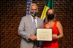 US Chargé d'Affairs Douglas Koneff awarding Women who Make a Difference prize to Dr. Cristina Castro for activism against violence towards women