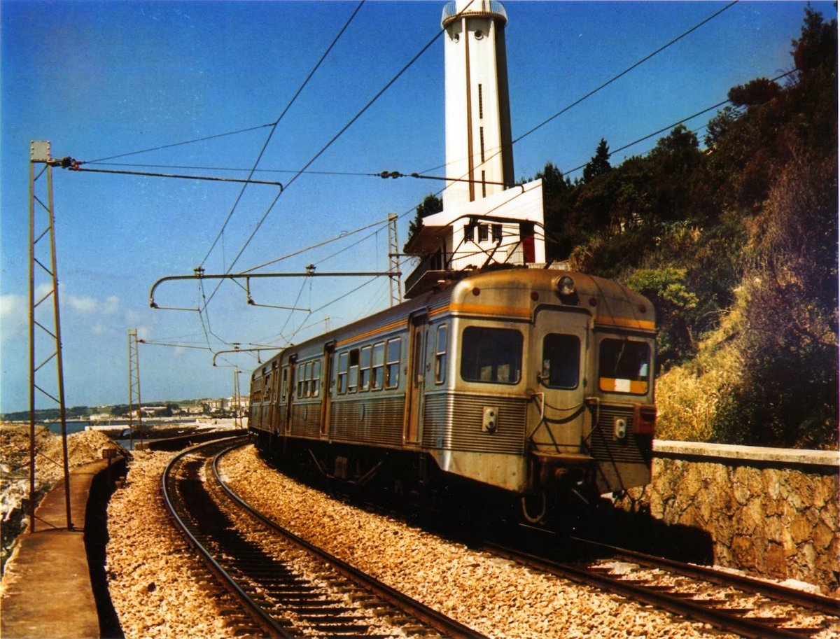 Vintage Sorefame train composition of the Cascais line near Gibalta lighthouse in the mid-1960s