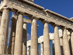 View of the Acropolis in Athens Greece with ancient ruins on a hilltop under a blue sky