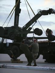 Marines unloading equipment to remove F/A-18 Hornet after emergency landing at Combat Center