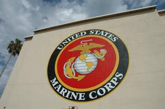 Artists painting a giant 40-foot Marine Corps seal on a wall at Marine Corps Air Station Miramar using a 60-foot boom