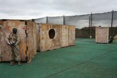 Marine in camouflage aiming paintball gun on paintball field at Marine Corps Air Station Miramar