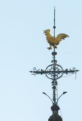 Weather vane on the roof of Santa Efigenia Church with a cloudy sky background