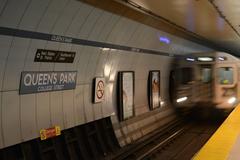 Queen's Park Subway Station interior with subway train and passengers in Toronto