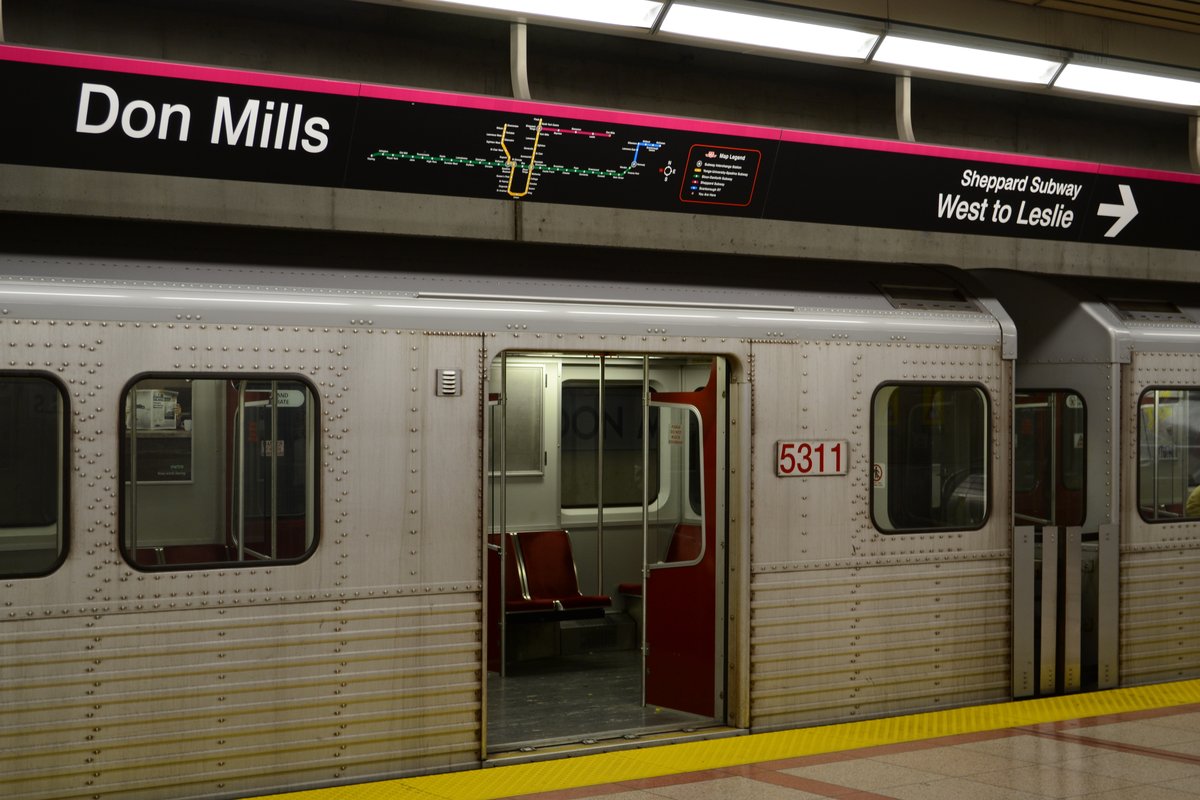 Don Mills Station Toronto subway entrance with red Train at platform