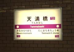 Tenmabashi Station entrance on Osaka Subway with people walking and clear blue sky