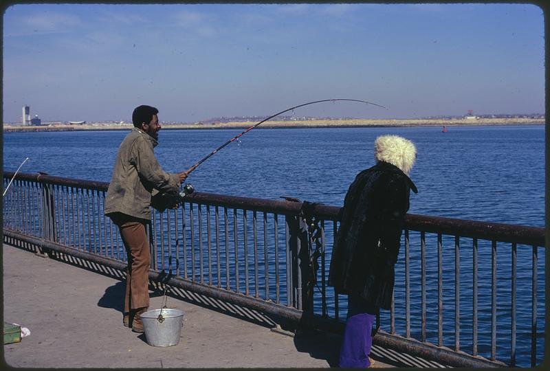 Activity on McCorkle Fishing Pier at Castle Island Boston Harbor recreation area with people fishing and enjoying the waterfront