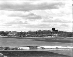 Gamla Uppsala church with burial mounds to the left in black and white photograph from the 1940s