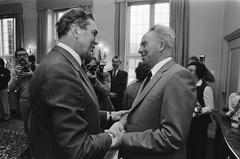 Farewell reception of W. Akse, caretaker of Catshuis, shaking hands with Biesheuvel, 1982 black and white photo