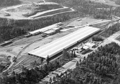 Aerial view of newly completed Högdalsdepån with Högdalstoppen under construction in the background and Prols factory building in the foreground in Högdalens industrial area