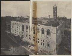 Construction progress of exterior wall and second floor windows of McKim Building at Boston Public Library, with Bates Hall and stairwell interior walls visible