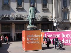 Statue of Nils Ericson wearing earmuffs in front of Stockholm railway station with text 'Oh my gosh what a noise.'