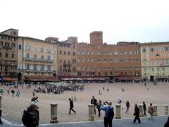 Panoramic view of Piazza del Campo in Siena with medieval buildings and a bell tower