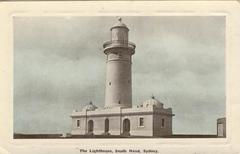 Historic view of Macquarie Lighthouse with surrounding trees under a cloudy sky