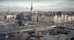 Panoramic view of Stockholm's Gamla Stan and French Bay with motorboats and tugboats, foreground of tracks and freight wagons in Stadsgården