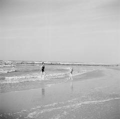 Princesses Beatrix, Irene, and Margriet walking on the beach near Huis ten Bosch palace in 1946, black and white photo