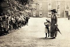 Children outside the city standing in front of Huis ten Bosch palace as Queen Wilhelmina and Princess Juliana walk past them in The Hague, Netherlands, 1914