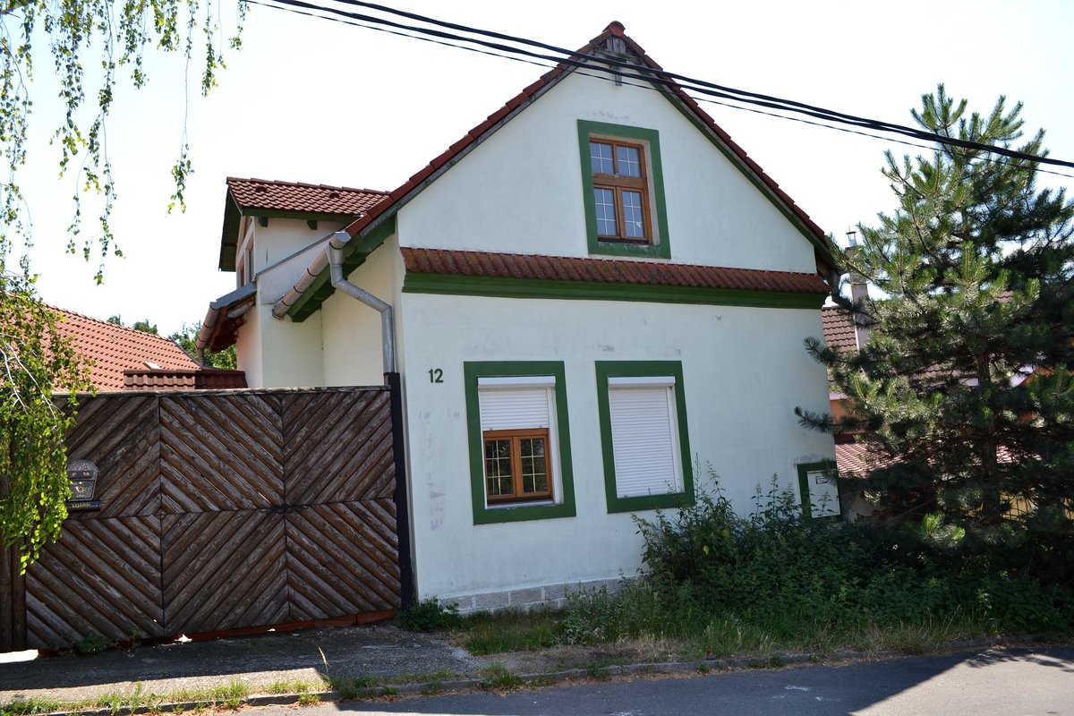 Street view of Primoravská Ulica in Devínska Nová Ves, Bratislava, Slovakia with residential buildings and cars