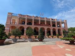 Exterior view of Ho Chi Minh Museum in Saigon with people walking nearby