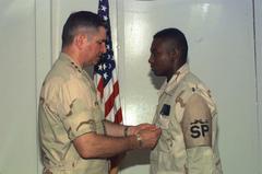 U.S. Air Force Chief of Staff Gen. Ronald R. Fogleman presenting the Airman's Medal to Senior Airman Corey P. Grice in Saudi Arabia, 1996