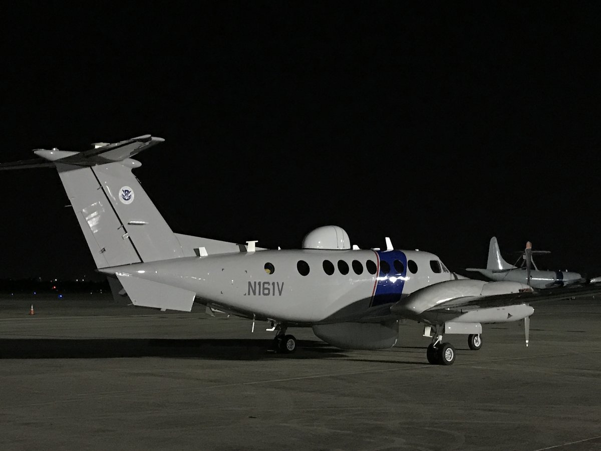 CBP Air and Marine Operations Multi-Role Enforcement Aircraft on tarmac with P-3 Airborne Early Warning aircraft in distance at Kelly Air Force Base TX