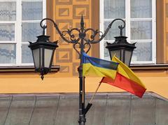 Flags of Warsaw and Ukraine hanging on a street lamp at Castle Square in Warsaw as a symbol of solidarity with Ukraine attacked by Russia